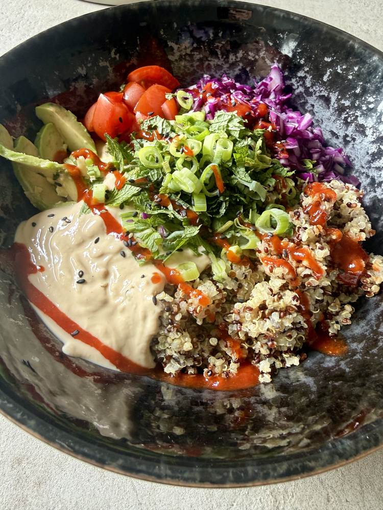 Bowl with quinoa, red cabbage, avocado, and silken tofu-peanut sauce